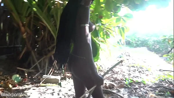 Naked skinny tribe woman making a bow to go hunting