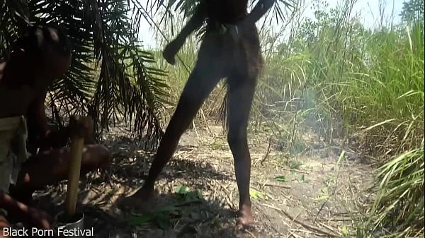 2 African tribe girls jerking off their chief with their asses in the river