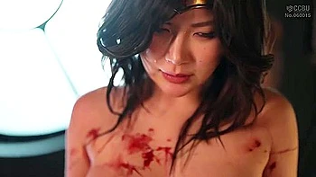 She is restrained and a vibrator is inserted and removed, and then thrust deep into her throat.