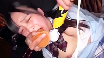 A dildo is thrust deep into her throat and a vibrator is inserted.