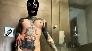 Большегрудая в латексном капюшоне дрочит в душе